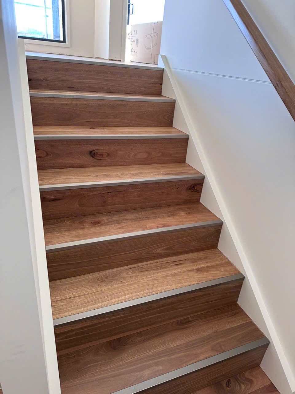 Timber treads with nosing trims climbing the new staircase.